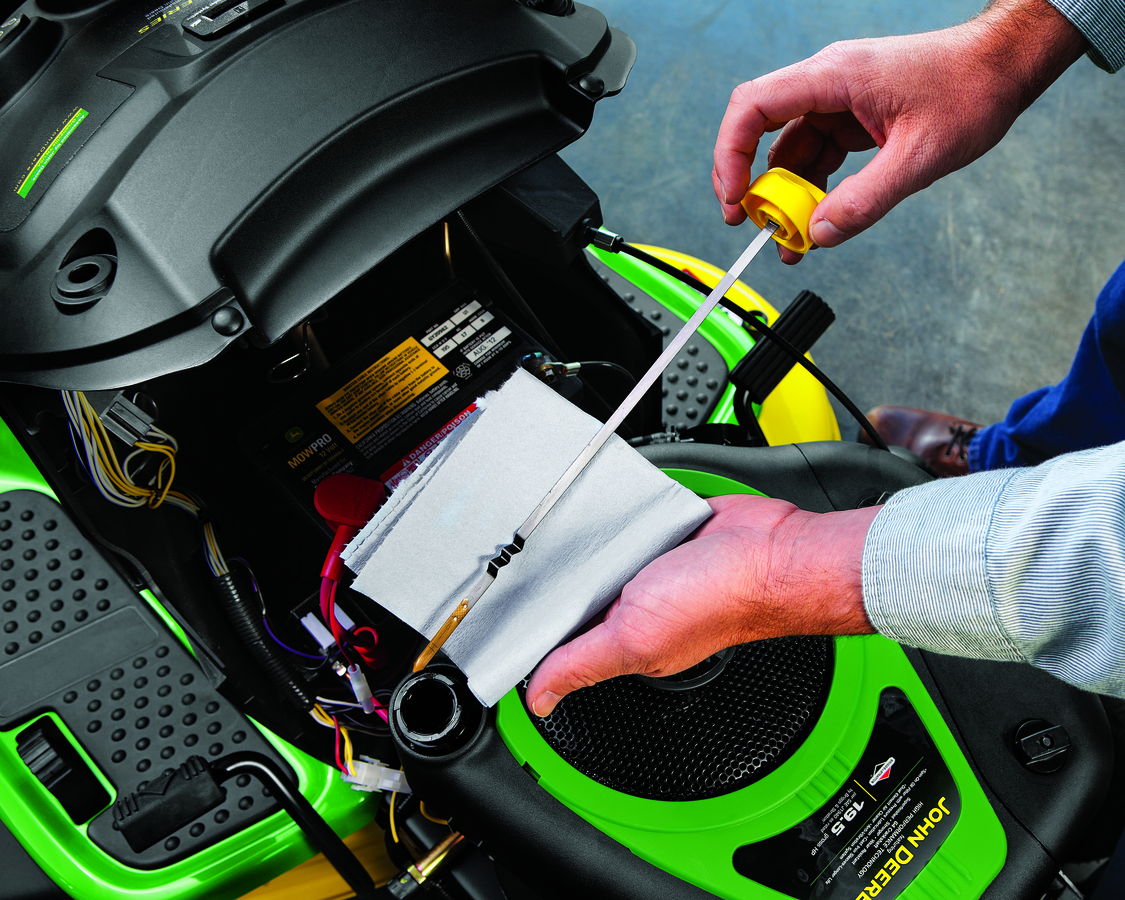 A John Deere Technician is repairing the John Deere farming tractor