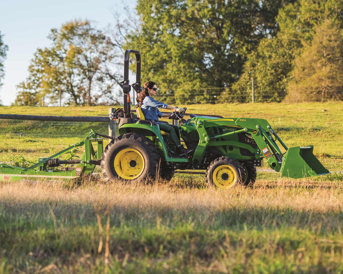 John Deere 3038 E tractor is mowing the lawn